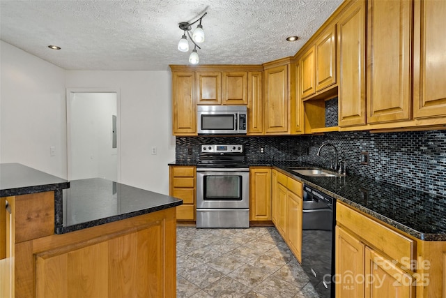 kitchen featuring backsplash, dark stone counters, stainless steel appliances, a textured ceiling, and a sink