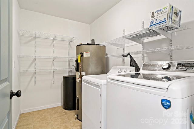 washroom with baseboards, water heater, laundry area, light tile patterned floors, and separate washer and dryer