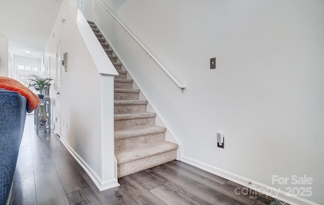 stairway with baseboards and wood finished floors