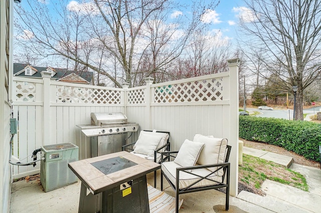 view of patio with an outdoor fire pit, fence, and a grill