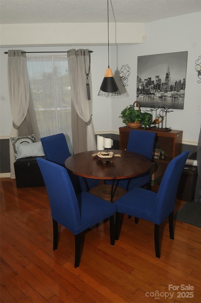 dining space featuring a textured ceiling and hardwood / wood-style floors