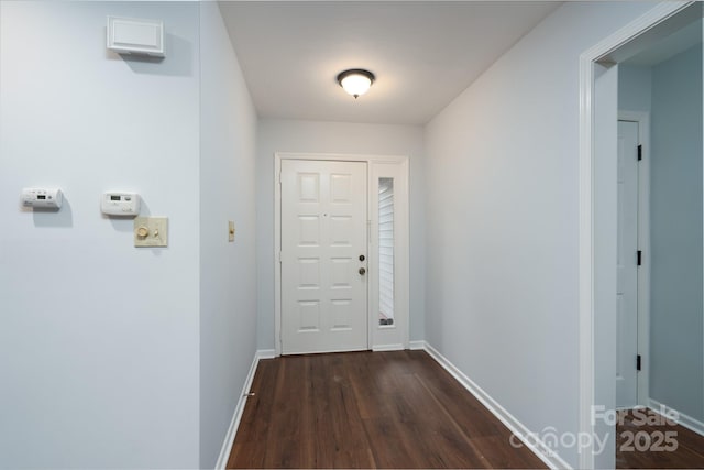 doorway to outside with dark wood finished floors and baseboards