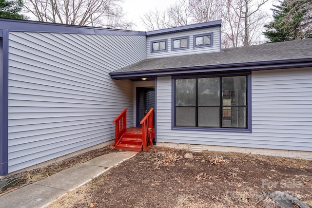 property entrance with a shingled roof