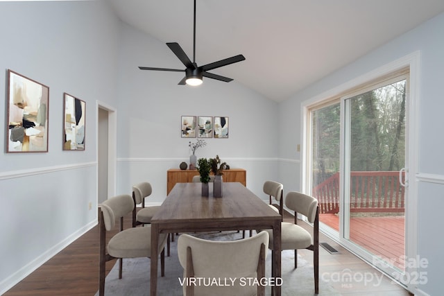 dining room featuring a ceiling fan, wood finished floors, visible vents, baseboards, and vaulted ceiling