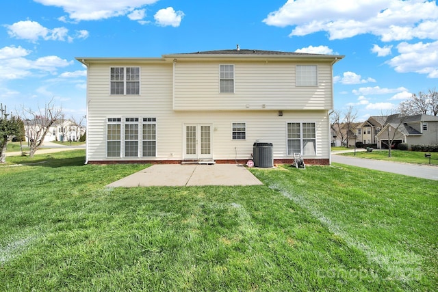 rear view of property featuring a patio, a yard, central AC unit, and french doors