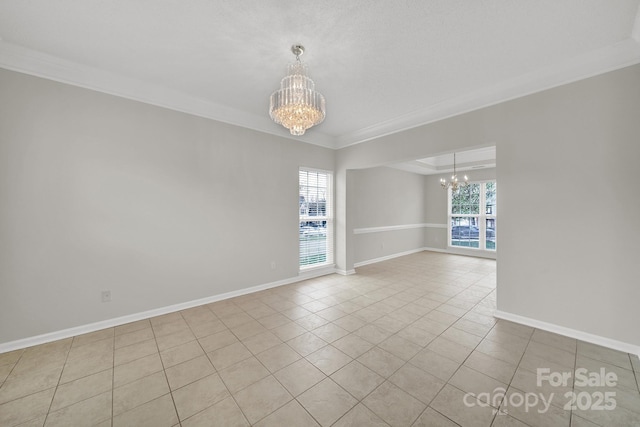 empty room featuring baseboards, a notable chandelier, a healthy amount of sunlight, and crown molding