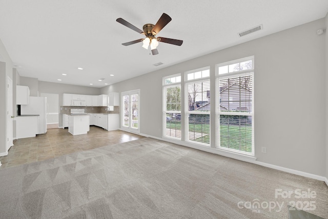 unfurnished living room featuring visible vents, baseboards, light carpet, recessed lighting, and a ceiling fan