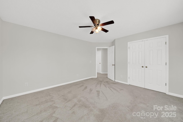 unfurnished bedroom with a closet, ceiling fan, baseboards, and carpet floors