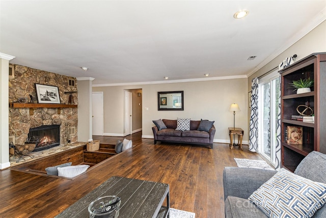 living area featuring baseboards, ornamental molding, a fireplace, and hardwood / wood-style flooring