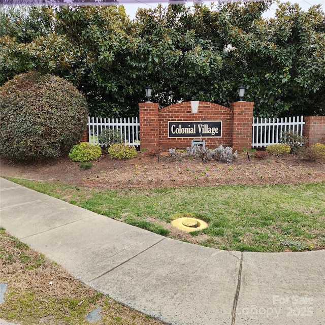 community / neighborhood sign with fence