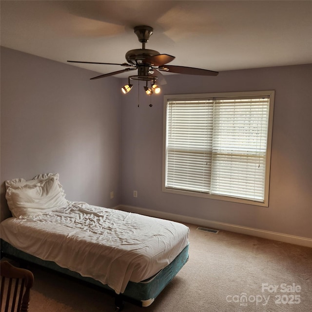 bedroom with a ceiling fan, baseboards, visible vents, and carpet floors