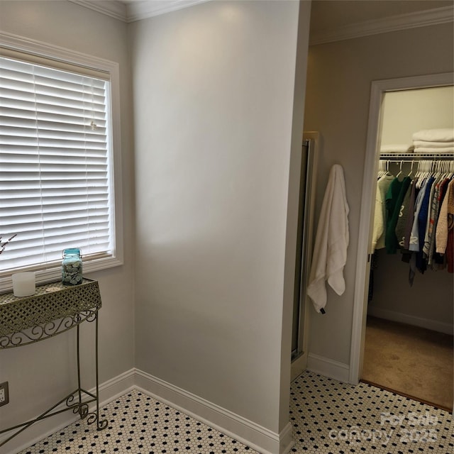 full bathroom featuring a walk in closet, baseboards, a stall shower, and ornamental molding