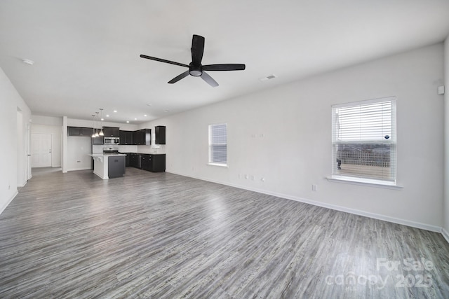 unfurnished living room featuring visible vents, a ceiling fan, wood finished floors, recessed lighting, and baseboards