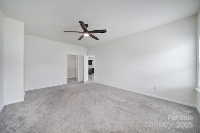 empty room featuring baseboards, ceiling fan, and carpet floors