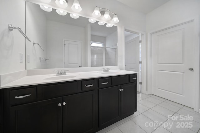 full bathroom featuring a sink, double vanity, tile patterned floors, and a tile shower