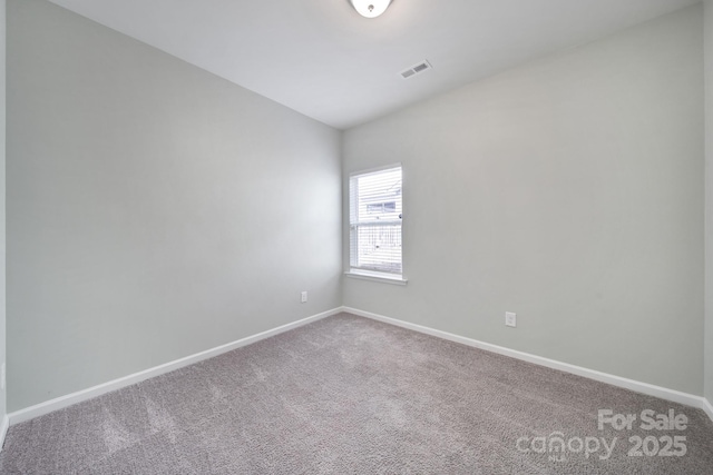 carpeted spare room featuring visible vents and baseboards