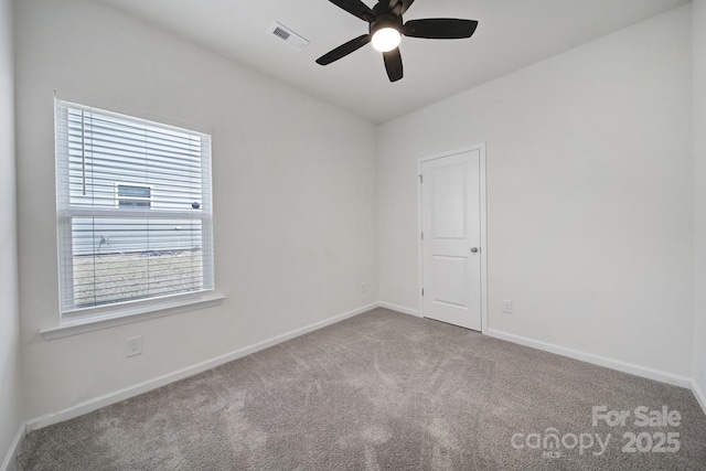 carpeted spare room featuring visible vents, baseboards, and ceiling fan