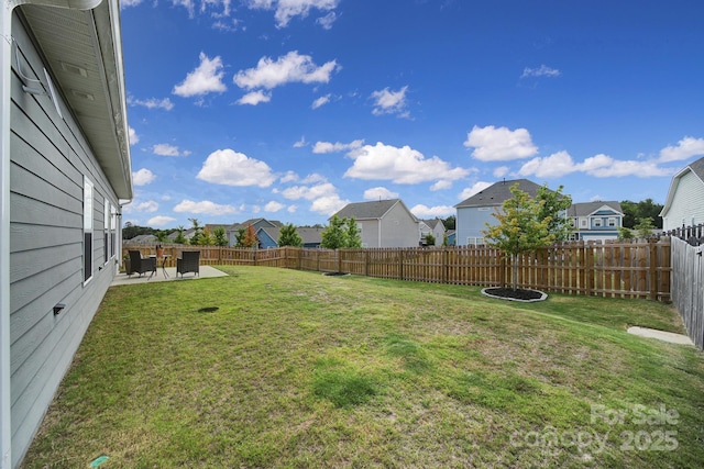 view of yard with a residential view, a fenced backyard, and a patio area