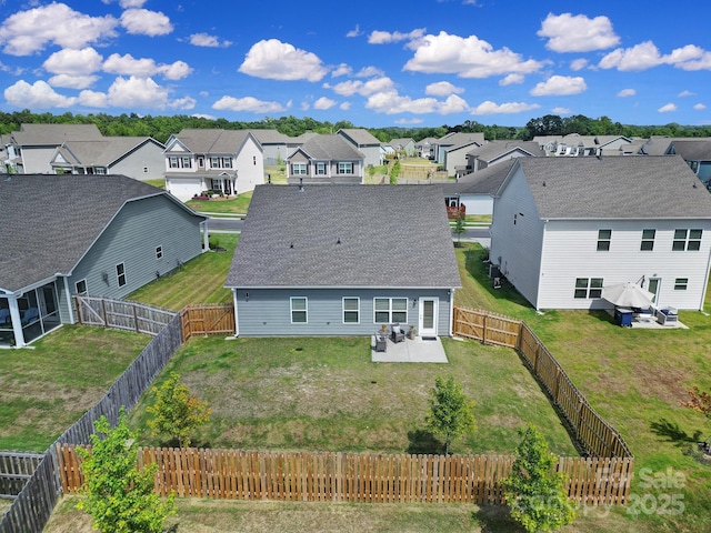 rear view of house featuring a residential view, roof with shingles, a yard, a fenced backyard, and a patio area