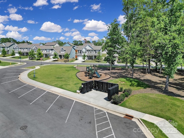 view of community featuring uncovered parking, a residential view, and a lawn