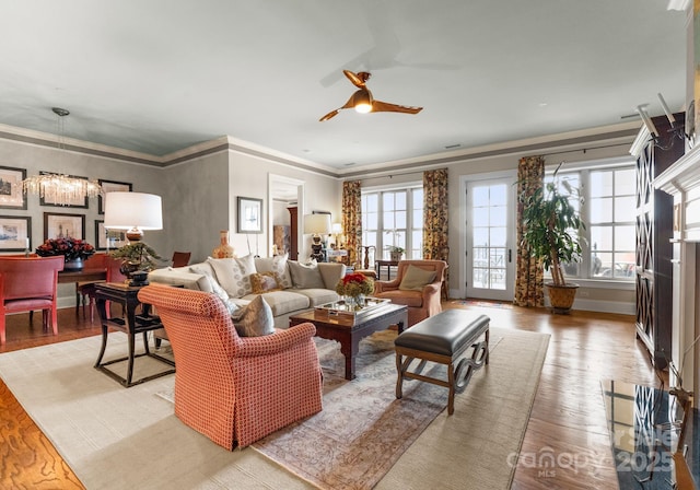 living room with ornamental molding, wood finished floors, and ceiling fan