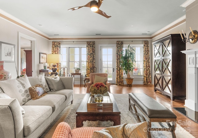 living room featuring visible vents, ornamental molding, ceiling fan, and wood finished floors