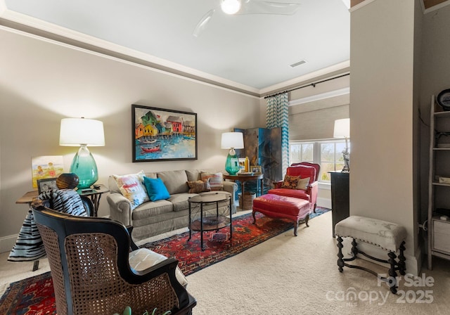 living area featuring carpet flooring, a ceiling fan, visible vents, and ornamental molding