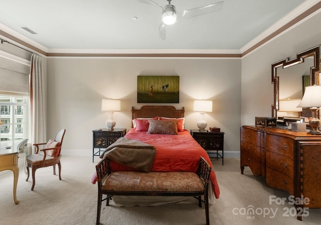 carpeted bedroom featuring visible vents, baseboards, ornamental molding, and a ceiling fan