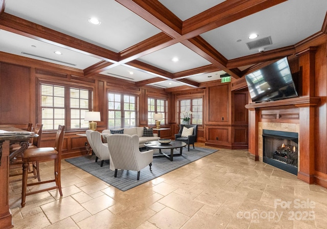 living area with beam ceiling, stone tile floors, and coffered ceiling