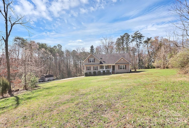 view of front facade with a wooded view and a front lawn