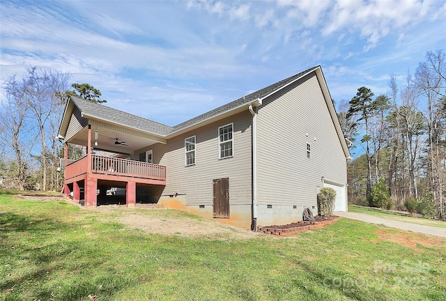 back of house featuring a lawn, a garage, concrete driveway, crawl space, and ceiling fan