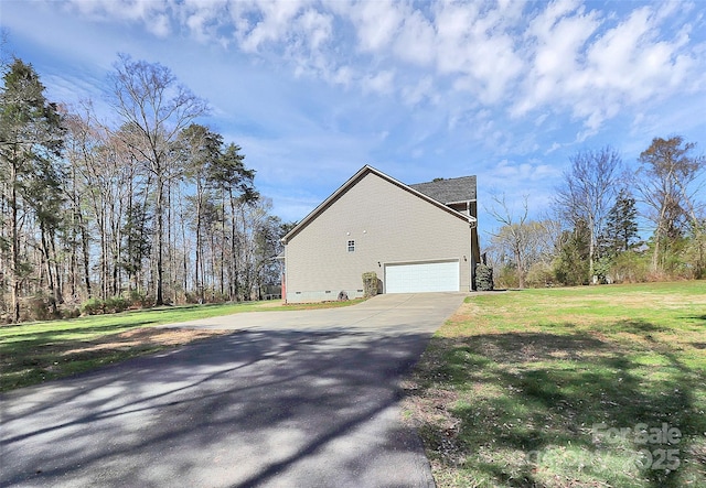 view of side of home with concrete driveway, a lawn, and crawl space