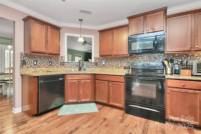 kitchen with visible vents, crown molding, light wood-style flooring, black appliances, and a sink