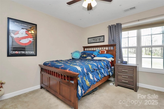 carpeted bedroom with visible vents, baseboards, and a ceiling fan