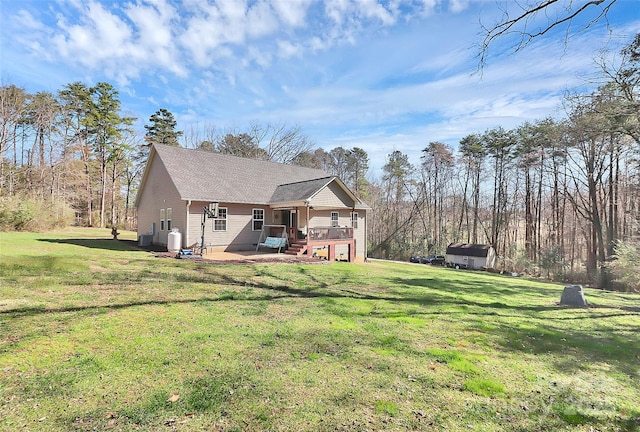 back of house with a lawn, a wooden deck, a patio, and a shingled roof