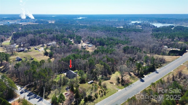 drone / aerial view with a wooded view