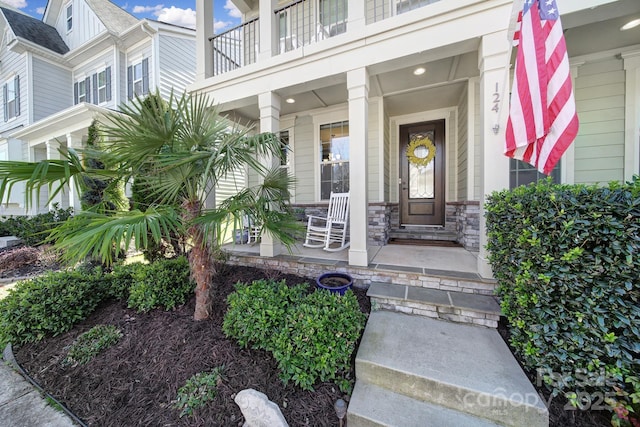 property entrance with a porch and stone siding