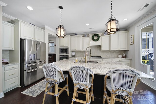 kitchen featuring visible vents, a sink, ornamental molding, stainless steel appliances, and dark wood-style flooring