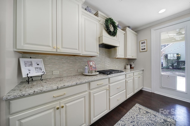 kitchen with a wealth of natural light, dark wood finished floors, tasteful backsplash, and stainless steel gas stovetop