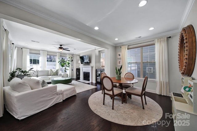 dining space with visible vents, a fireplace with flush hearth, recessed lighting, ornamental molding, and dark wood-type flooring