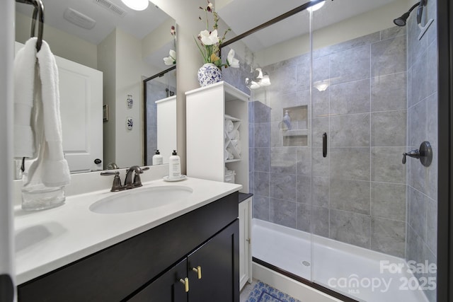 full bathroom featuring visible vents, a shower stall, and vanity