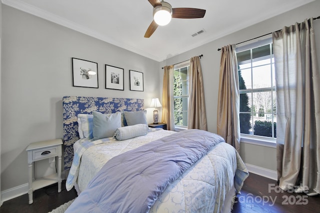 bedroom with visible vents, ornamental molding, a ceiling fan, wood finished floors, and baseboards