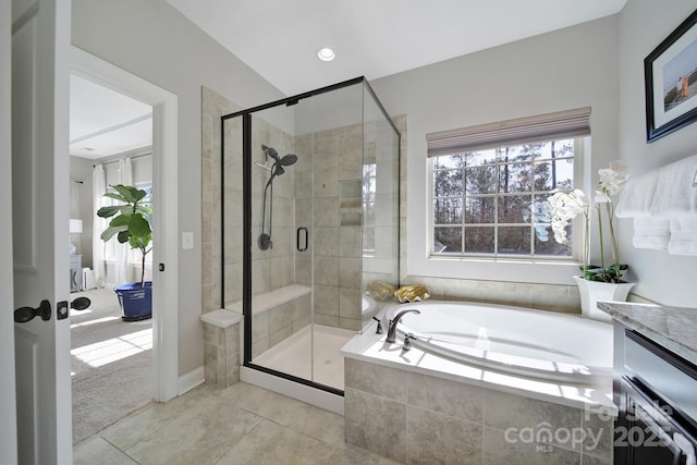 full bathroom featuring tile patterned flooring, a bath, vanity, and a stall shower