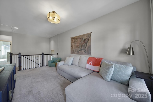 carpeted living area with recessed lighting and attic access