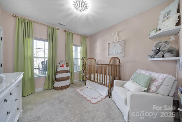 carpeted bedroom with visible vents and a nursery area