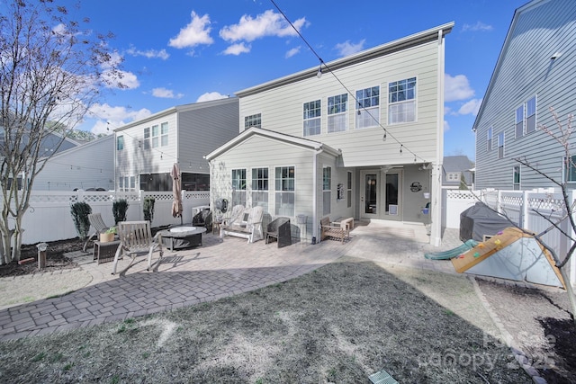 back of house featuring a patio, a fenced backyard, and an outdoor fire pit