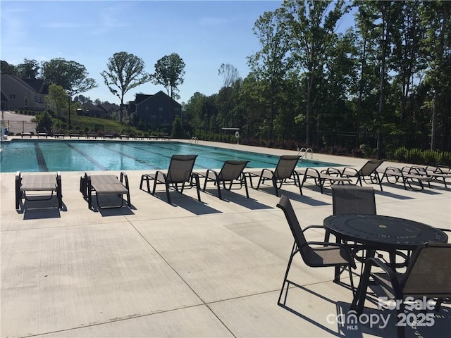 pool with a patio and fence