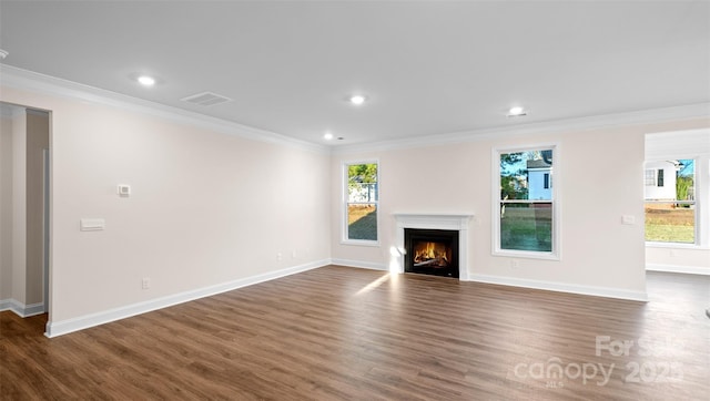 unfurnished living room featuring crown molding, a warm lit fireplace, visible vents, and dark wood finished floors