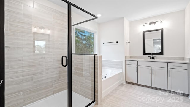 bathroom with a garden tub, vanity, and a shower stall