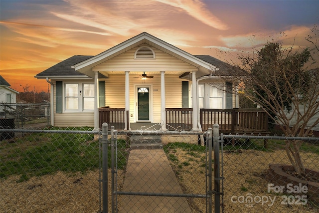 view of front of property featuring a fenced front yard, a porch, a shingled roof, and a gate